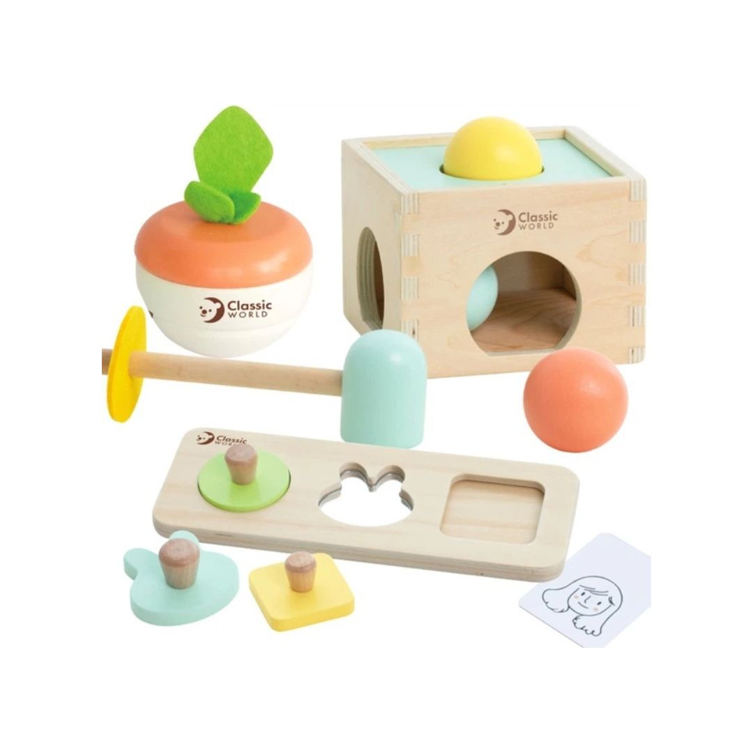 A Classic World wooden toy set arranged, including a shape sorter box, a fruit-shaped toy, a hammer, a sorting board, small pegs, and a card.