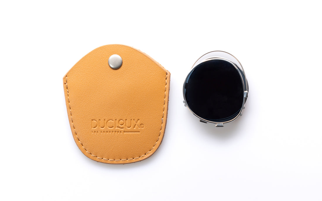 A tan leather protective case, shown next to a black clip on, on a clean white background. The case features a snap button closure and the brand name 'DUCLOUX' embossed on the front.