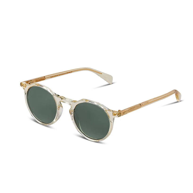 Round sunglasses with translucent off-white frames, gold metal rims, and dark green lenses, shown on a clean white background.