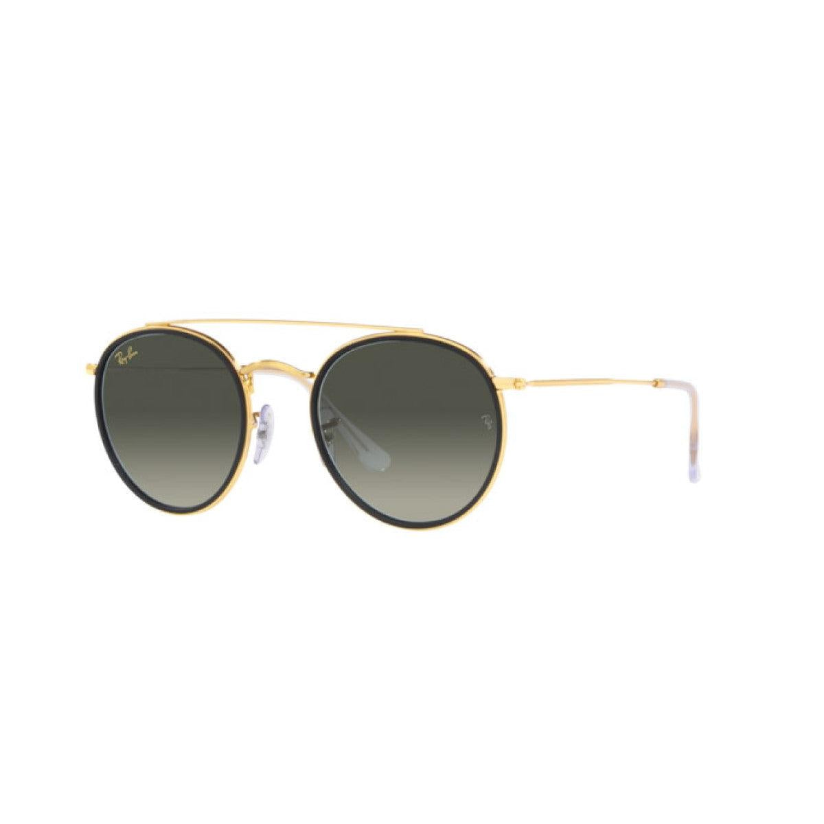 Round sunglasses with gold frame and dark  lenses on a white background