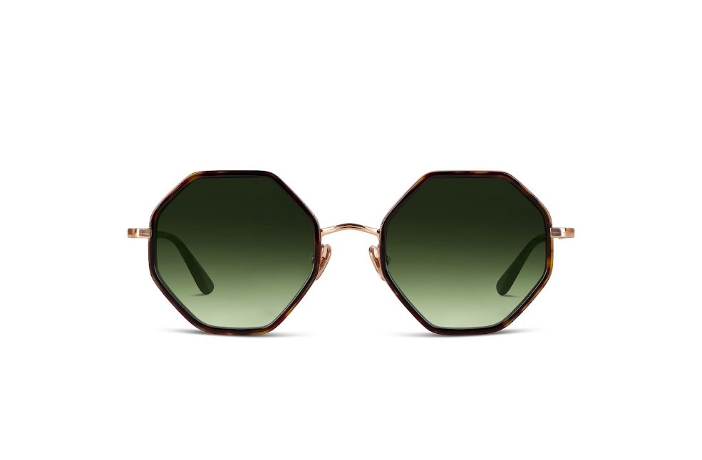 Hexagonal sunglasses with dark green gradient lenses, a tortoiseshell patterned frame, and a thin rose gold metal bridge and temples, shown against a plain white background.