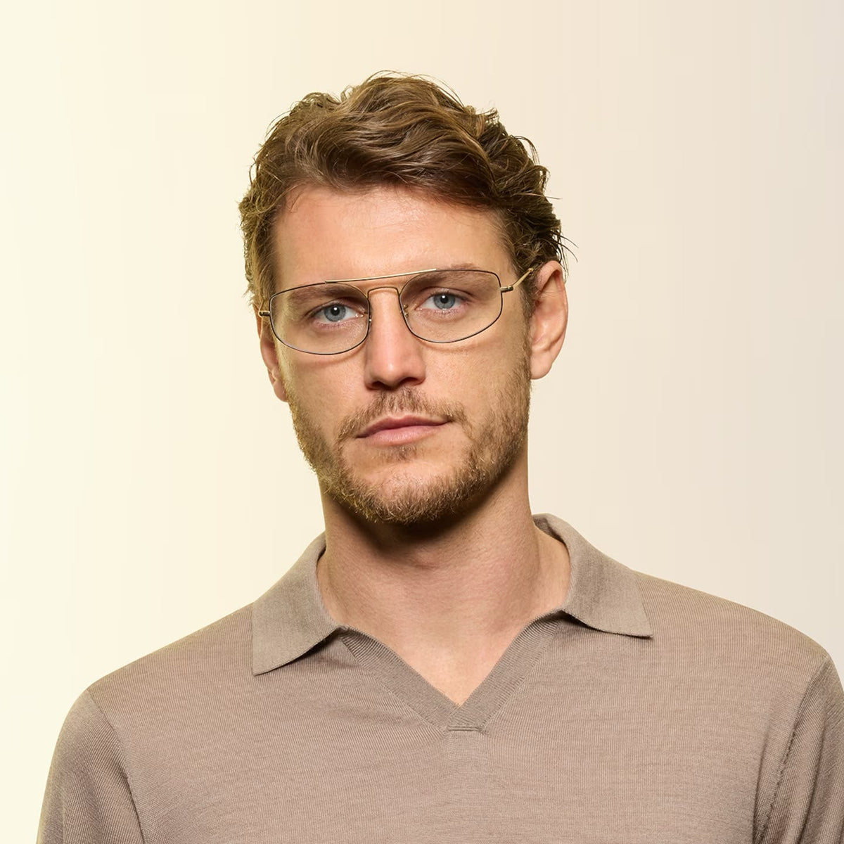 A man wearing eyeglasses on a simple background. 