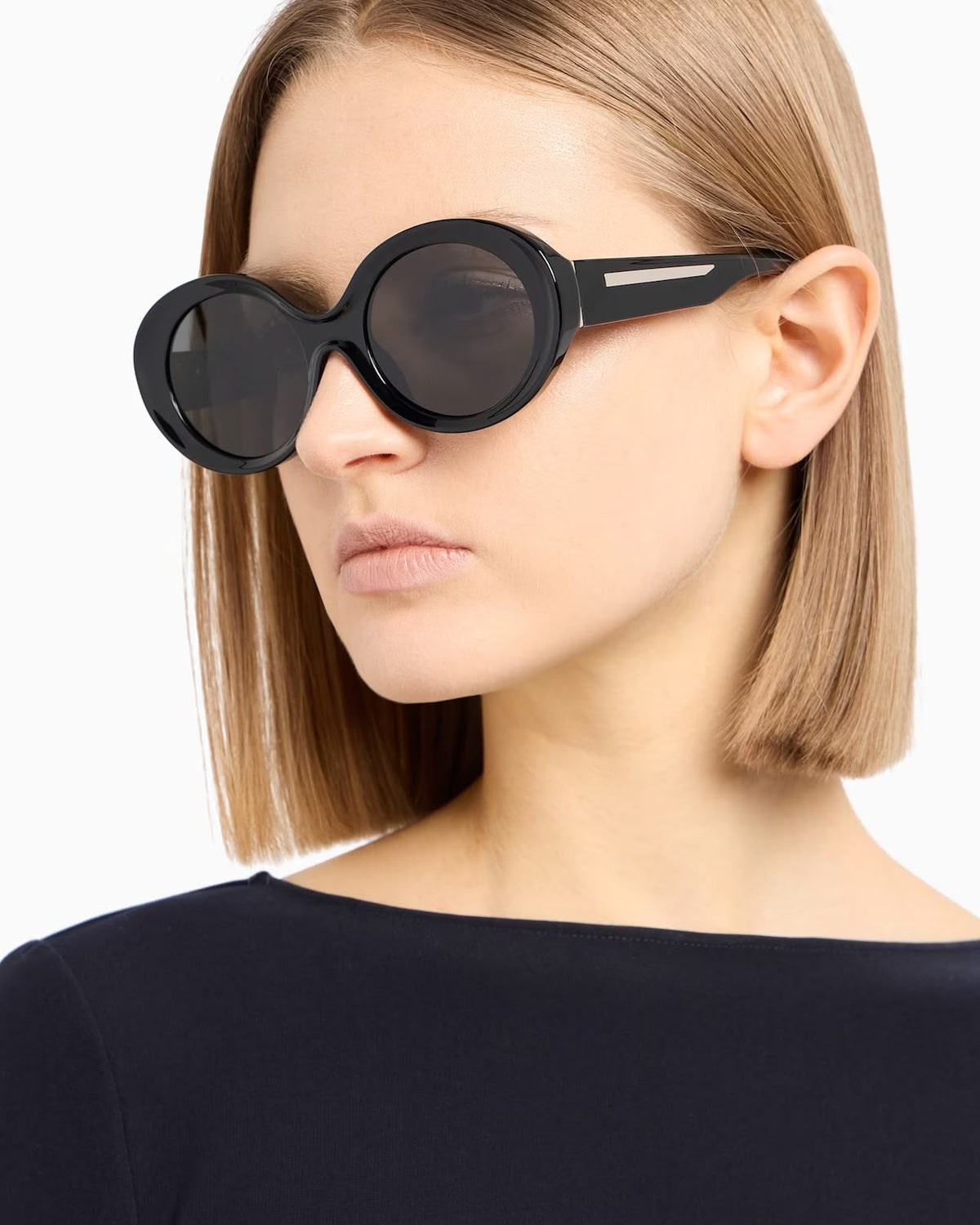 Side angle of a woman black sunglasses with dark tinted lenses n a white background. 