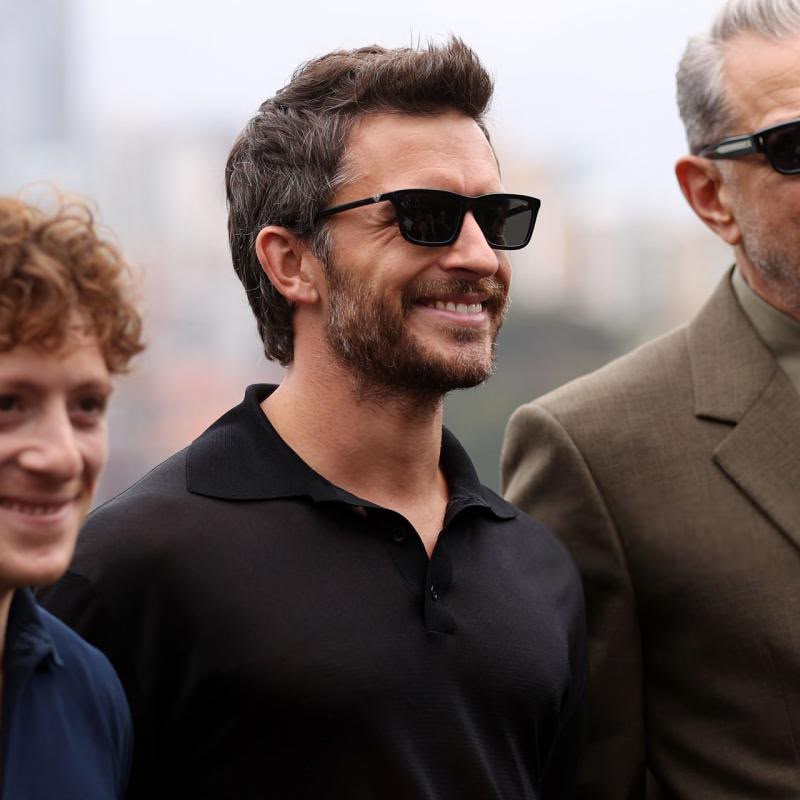 Side angle of a man wearing a pair of black sunglasses. 