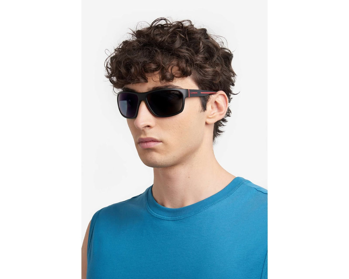 Side angle of a boy wearing black sunglasses with dark lenses on a white background. 
