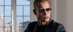Side angle of a man wearing black sunglasses with double bridge and dak lenses. 