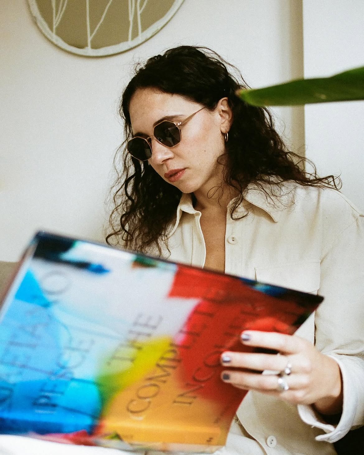 Side angle of a woman wearing gold framed sunglasses with dark lenses.